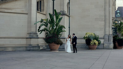 Groom in a classic black tux and the bride in front of the biltmore estate.