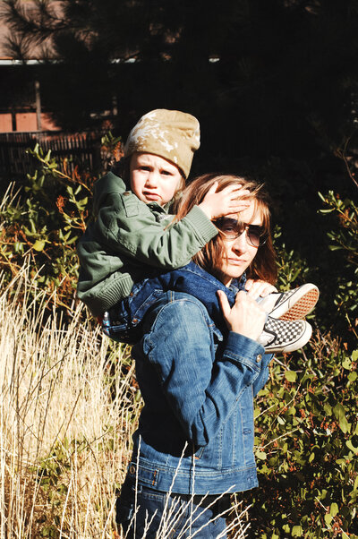 image of owner photographer Annie Robillard of annie x photographie with her son on her shoulders