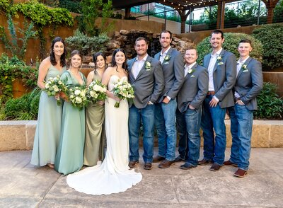 Wedding party at the courtyard of the Willows with bridal party holding bouquets in green and white