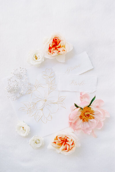 pink and orange flowers flatlay with invitation