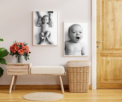 A cozy entryway with a wooden bench, a basket, a bouquet of flowers on a side table, and two black-and-white baby photos—captured by a Jacksonville newborn photographer—adorn the wall above the bench. A wooden door is on the right.
