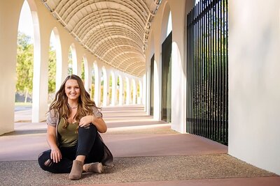 high school senior sitting in an outdoor hallway