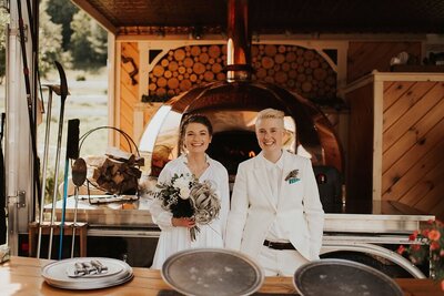 Brides standing together holding hands inside wedding venue, Berkshire Farm Wedding