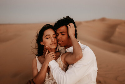 couple embracing in sand dunes