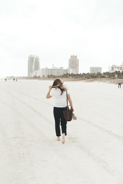 Woman walking on white sand beach