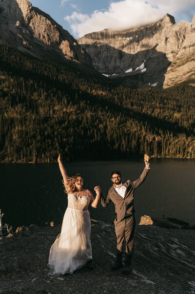 A couple celebrates in the bright sun at Sun Point in Glacier National Park after their vows during their Montana Elopement.