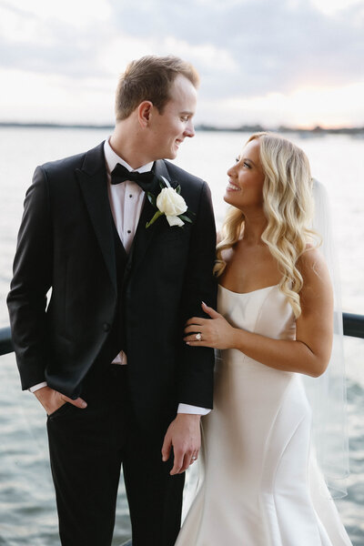 Bridal portraits on balcony overlooking the water at sunset