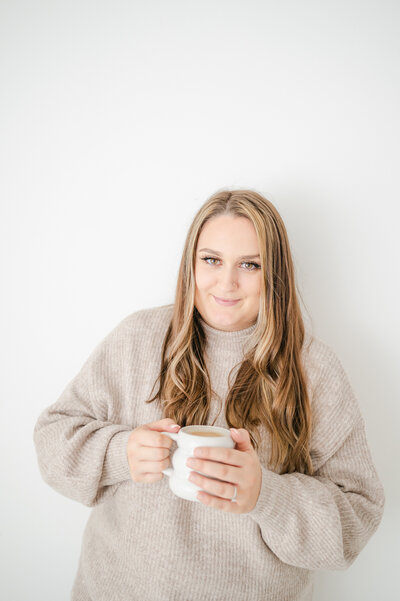 Girl smiling holding a hot drink at Billingshurst photography Studio