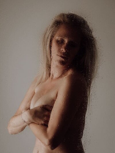 Intiem portret van vrouw die haar lichaam omarmt, symboliseert acceptatie en trots.