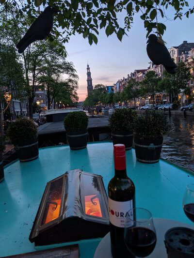 amsterdam sunset with a  dinner table and glass of wine
