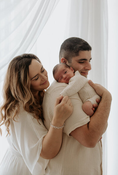 mother cradling newborn baby at indoor photography session in perth