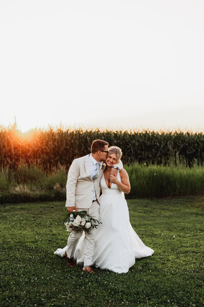 A wedding couple walks together in sunset.