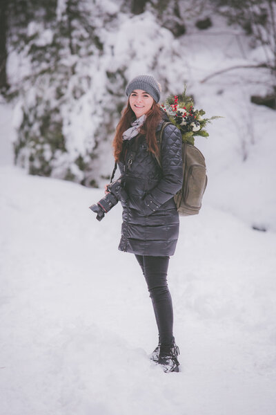Heather of Seeking Venture Photo carries  the bride's flowers in her backpack during a snowy winter elopement.