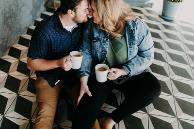 man and woman holding coffee mugs while looking at each other