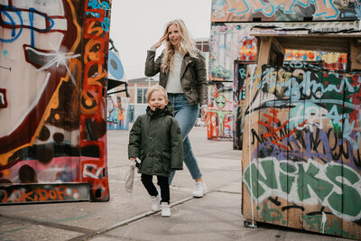 Spelenderwijs moment tussen ouders en kinderen tijdens gezinsfotoshoot door Leukfotografie in NDSM