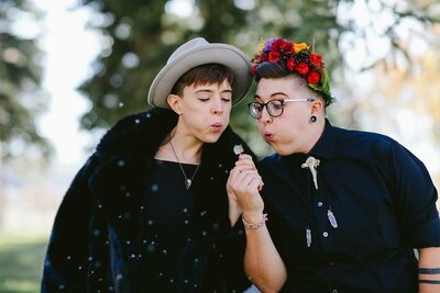 LGBTQ Couple blowing dandelion Wedding Day in Gunnison, Colorado