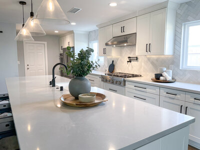 White Shaker Kitchen Cabinets with Black Hardware and Grey quartz countertops