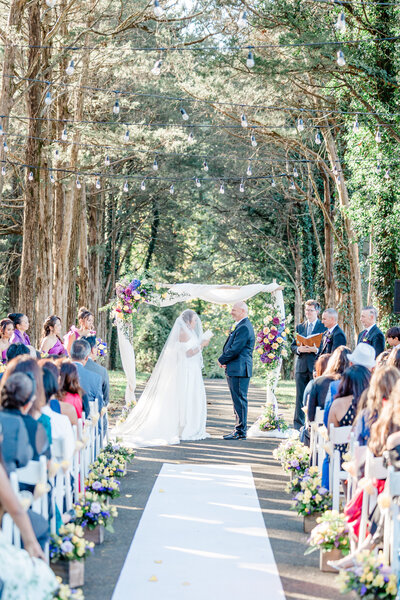 newlyweds looking at each other holding bouquet