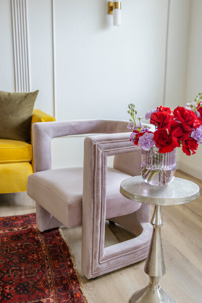 modern pink velvet chair by a table with flowers