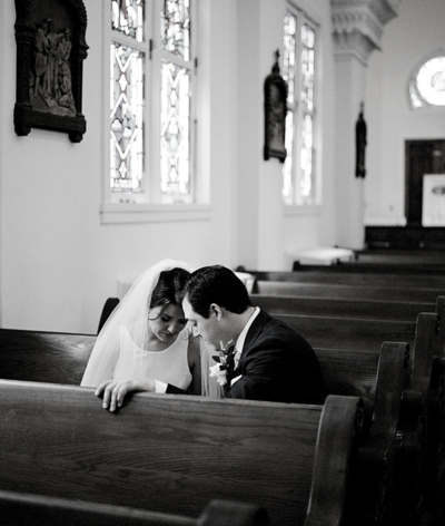 bride and groom praying at church
