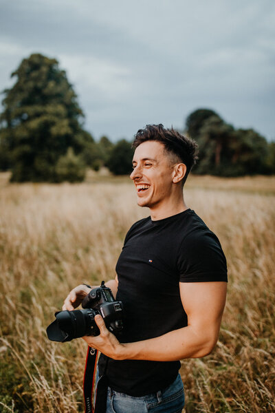 Ollie Baines with camera in hand at outdoor photoshoot