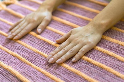 Hands on an Ayurvedic yoga mat