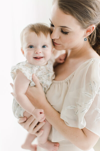 Mom with six month old baby girl in light and airy photography studio