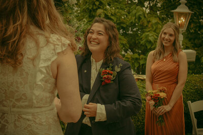 Newlyweds hold hands and run out of the church together, surrounded by streamers and loved ones