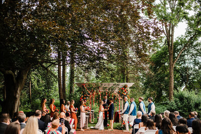 Overview of wedding ceremony with bridal party and some guests in frame, Blended wedding at Peirce Farm at Witch Hill