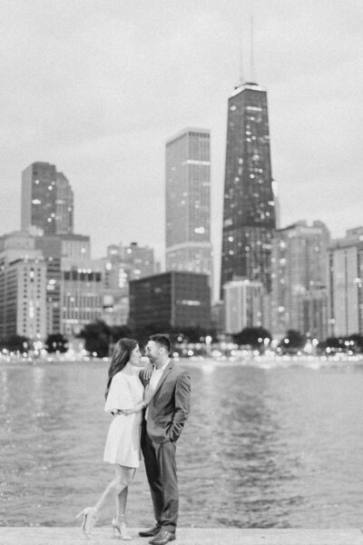 Couple posing by Lake Michigan with the Chicago skyline behind them