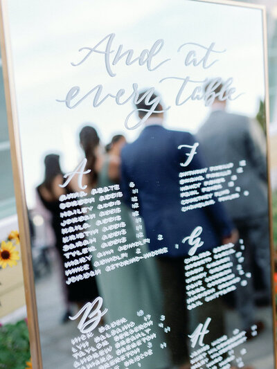 Mirror seating chart with hand lettering for Connecticut shoreline wedding