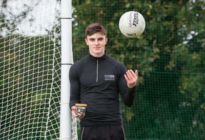 Kerry GAA Footballer beside goalpost throwing  football