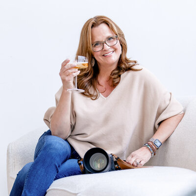 photo of Andrea Topalian on couch with glass of champagne