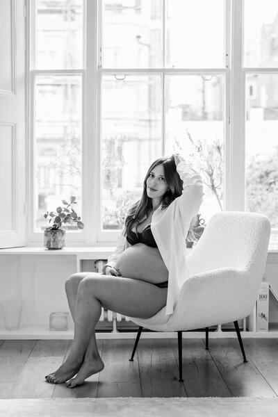 Black and white photograph of pregnant mother sitting with baby bump