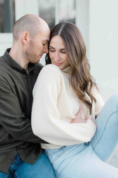 Engagement photo of a couple sitting on steps holding eachother