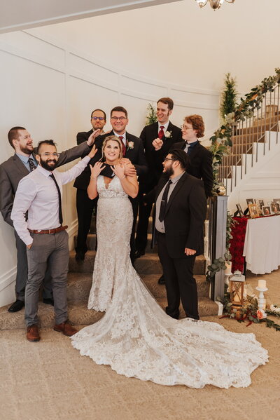 Wedding party standing on staircase smiling