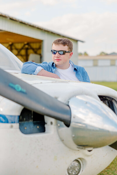 fayetteville nc high school senior leaning on a plane at aviation center