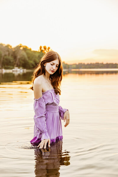 brown haired high school girl playing in the water during her senior photo session