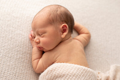 newborn portrait of boy sleeping with waffle textured blanket