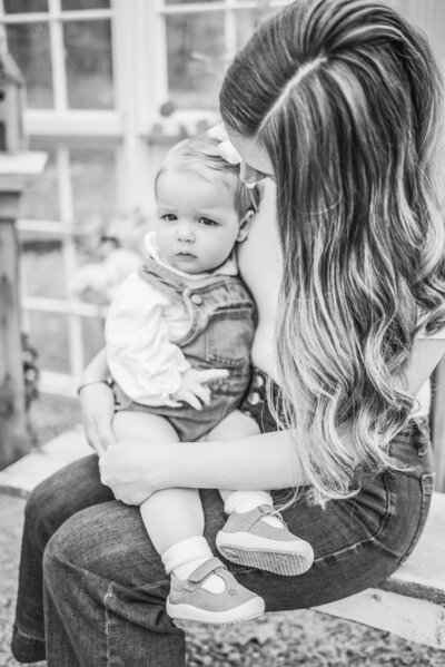 Mom embraces toddler girl in black and white photo taken by Dawsonville Photographer.