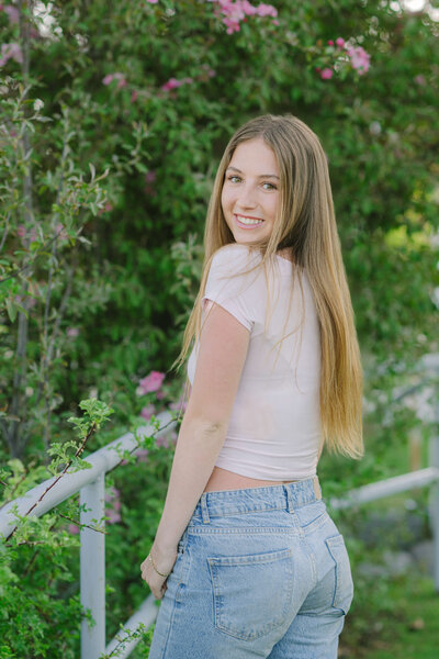 Truckee senior girl portrait spring blossoms in back, girl looking over shoulder and smiling
