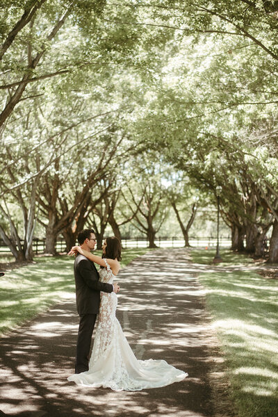 Couple Embracing  in Tree Lined Drive - Kayla & Bill | Oakshire Estate & Airfield Luxury Wedding Yakima Washington