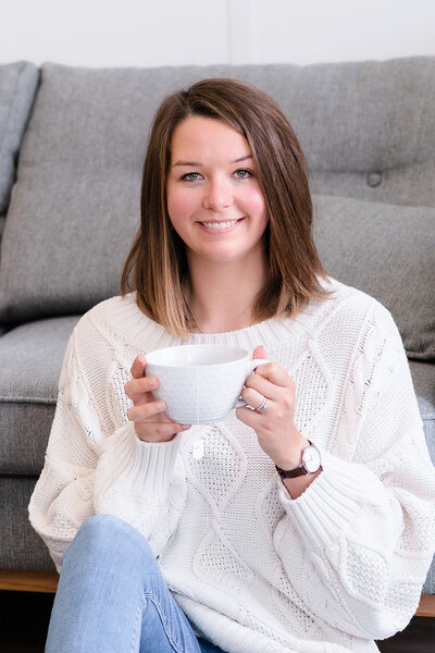 Photo de Samantha Guay tenant un mug de thé et souriant à la caméra