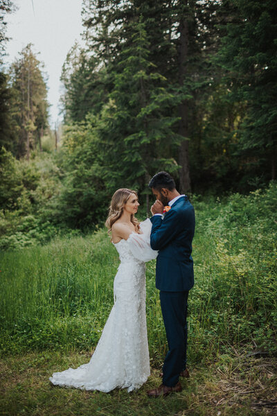couple kissing in forest on wedding day