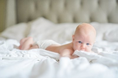 baby with bright blue eyes on white sofa