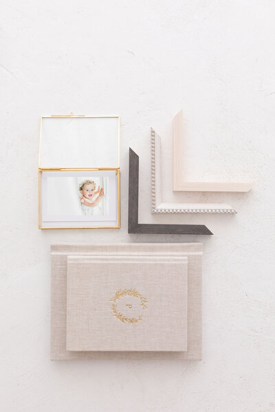 framed newborn  & family photos on a wall and on top of a dresser