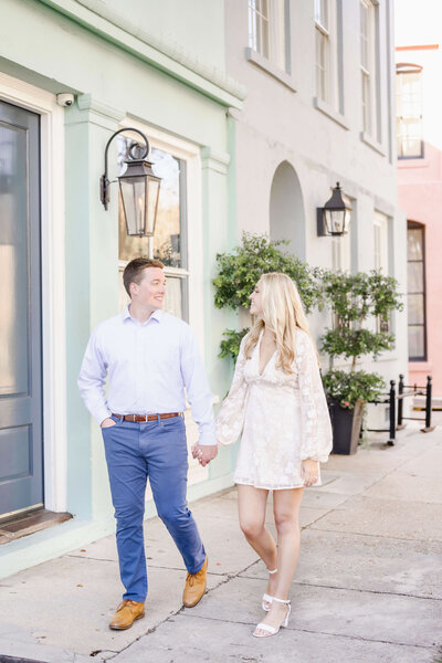 couple walking during engagement session on Rainbow Row