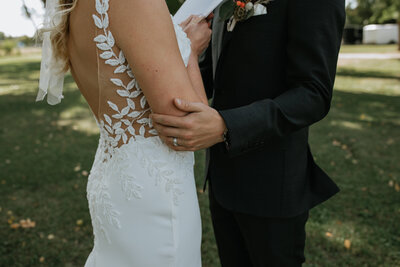 close up of groom touching brides arm  taken by fargo wedding photographer kiella lawrence