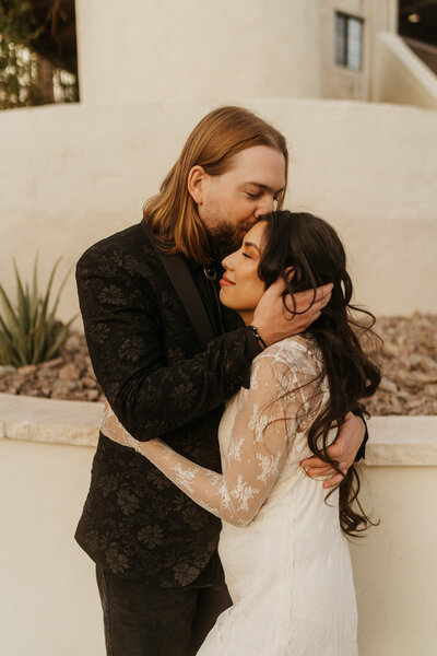 A person kissing their partner on the forehead