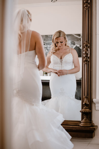 bride looks at her reflection in the mirror